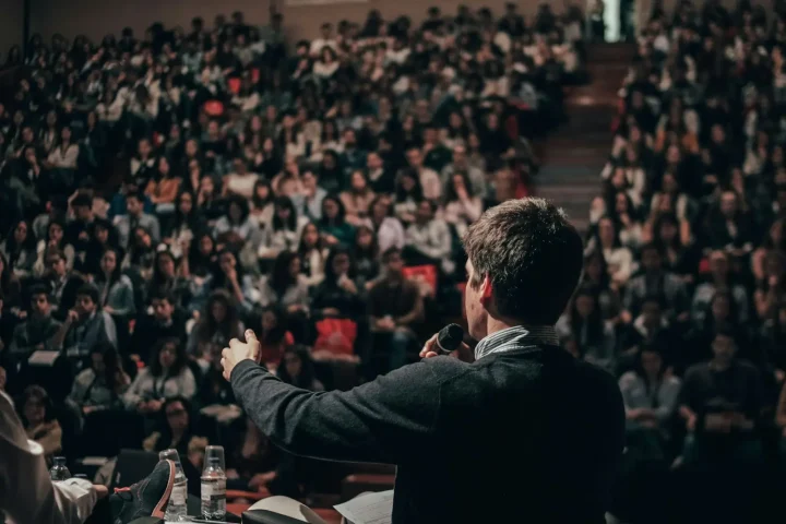 Speaker addressing a full auditorium