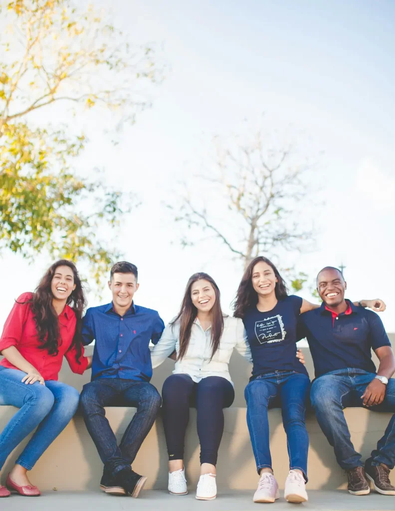 Group of friends sitting on a campus wall