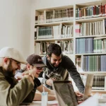 Students laughing around a table in the library