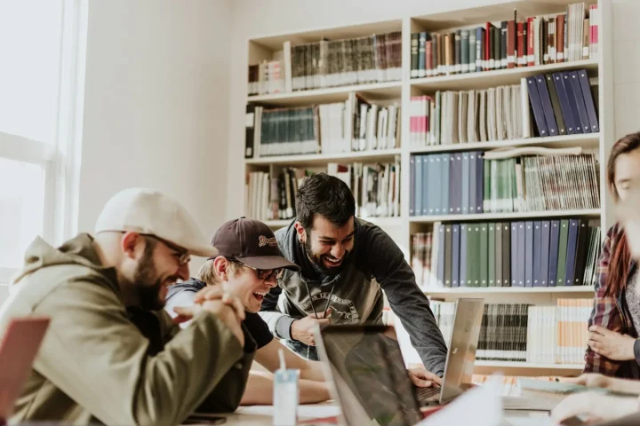 Students laughing around a table in the library