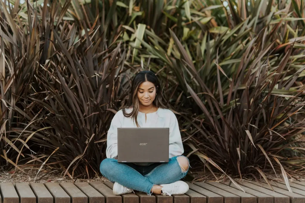 Student studying outdoors with a laptop