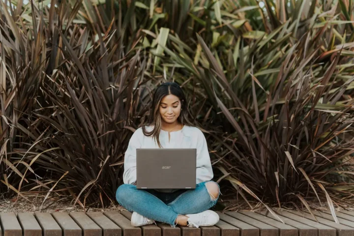 Student studying outdoors with a laptop