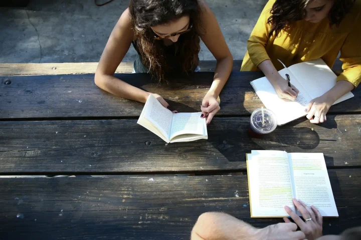 Students reading at a wooden study table
